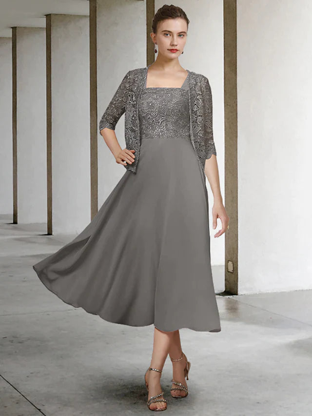 Woman wearing an elegant A-line two-piece Mother of the Bride dress with scoop neck and half sleeves.