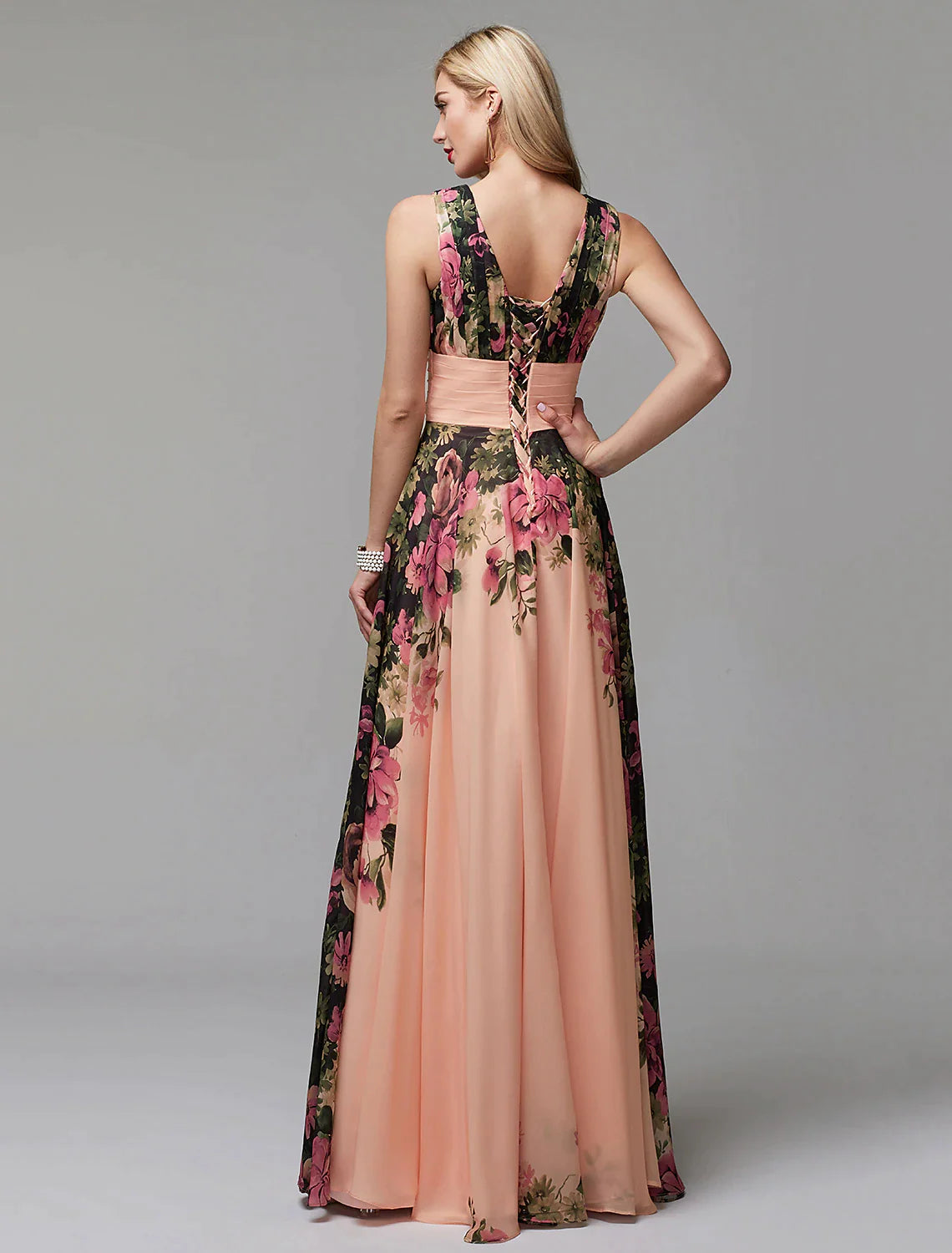 Back view of a woman in a floral A-line V-neck chiffon gown, showcasing the flowing skirt.