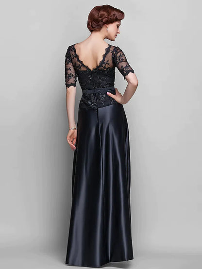 Side view of a woman in a navy A-line Mother of the Bride dress with half sleeves and lace details.