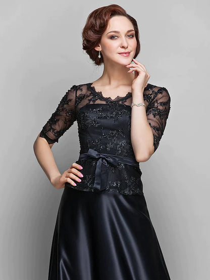 Close-up of the V-neckline and half sleeves with lace and beading on the navy Mother of the Bride dress.