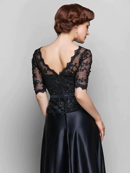 Woman posing in a navy A-line Mother of the Bride dress, highlighting the satin fabric and elegant drape.