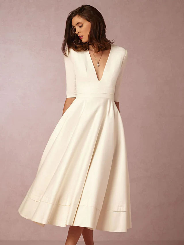 Back view of a dark A-line V-neck half sleeve tea length dress.