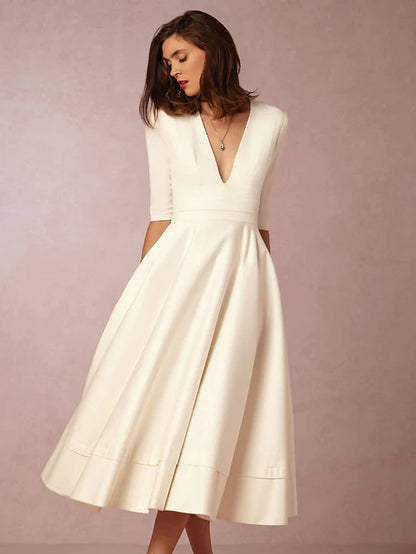 Back view of a dark A-line V-neck half sleeve tea length dress.
