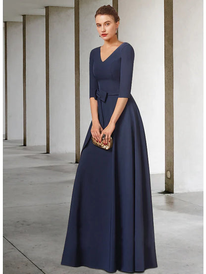 Sophisticated dark blue mother of the bride dress with a V-neck, half sleeves, and a flowing pleated skirt.