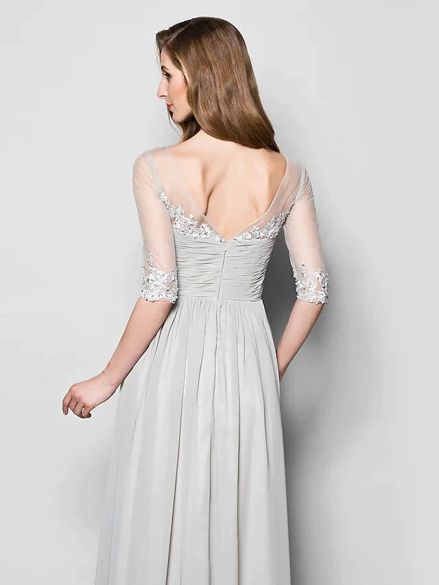 Side view of a woman in a floor-length chiffon tulle Mother of the Bride gown with V-neck and half sleeves.