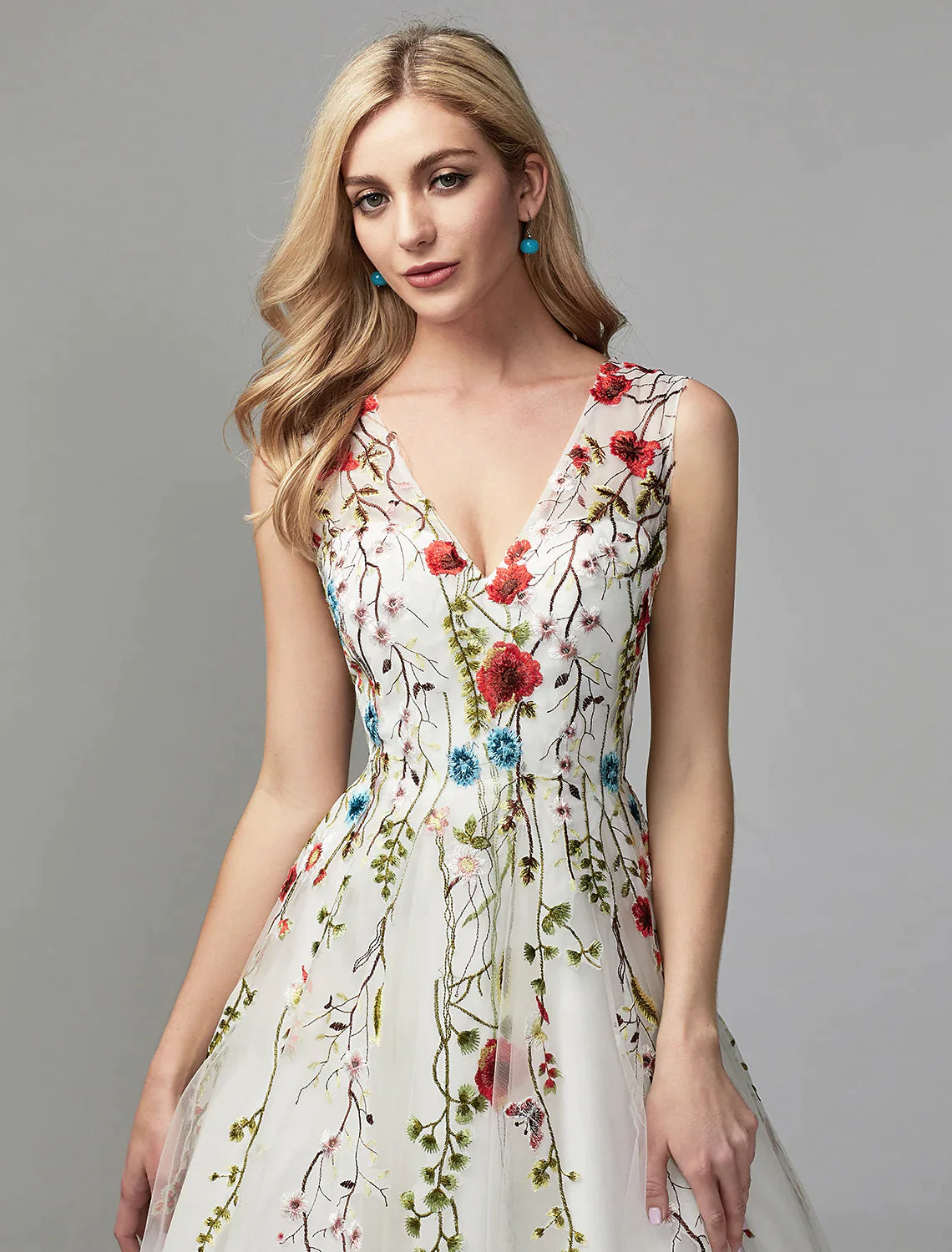 Close-up of the V-neckline and lace embroidery on the white A-line dress.