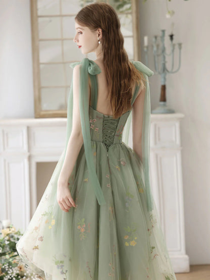 Full view of a green lace A-line high-low homecoming dress with intricate lace details.