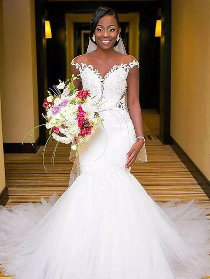 Elegant V-neck lace wedding dress with a chapel train and backless design.