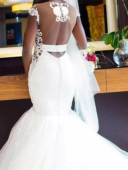Side view of the wedding dress, highlighting the chapel train and A-line silhouette.