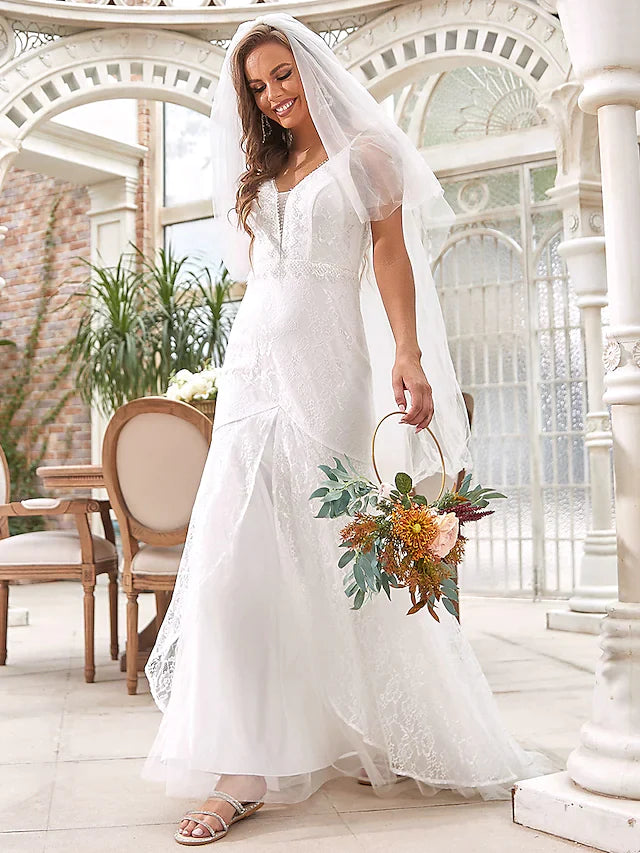 Bride wearing an elegant A-line V-neck lace and tulle wedding dress, full length view.