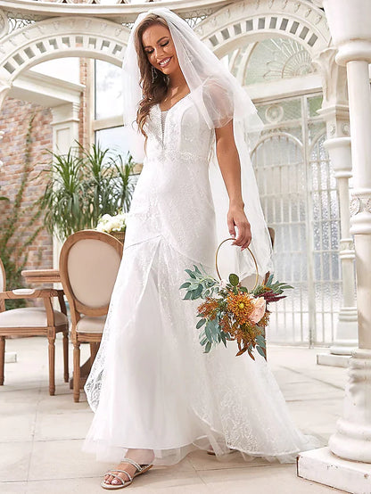 Bride wearing an elegant A-line V-neck lace and tulle wedding dress, full length view.
