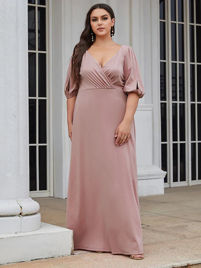 Close-up of the V-neckline and ruched detail on the green stretch satin dress.