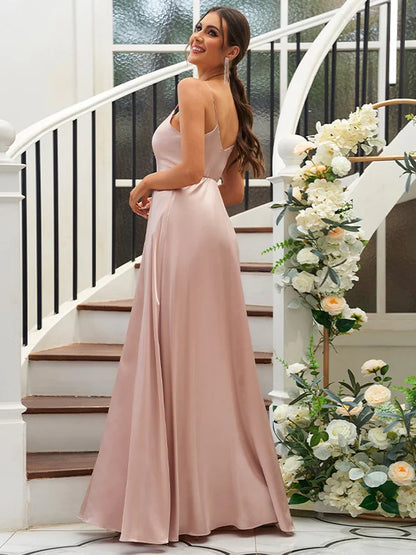 Back view of a woman in a floor-length A-line bridesmaid dress with ruffles.
