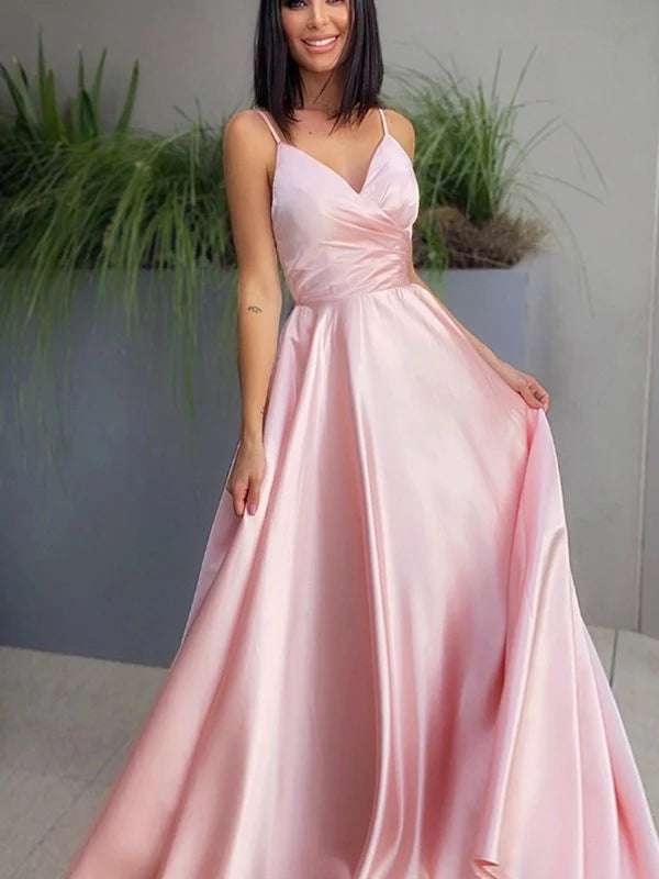 Woman wearing an elegant navy blue A-line V-neck satin ruched floor-length prom dress, front view.