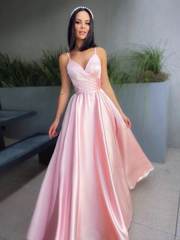 Side view of a woman in a navy blue A-line V-neck satin ruched floor-length prom dress.