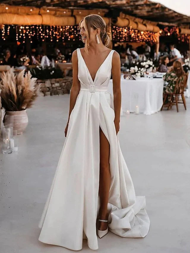 Bride in A-Line V-neck satin wedding dress with court train and split front.