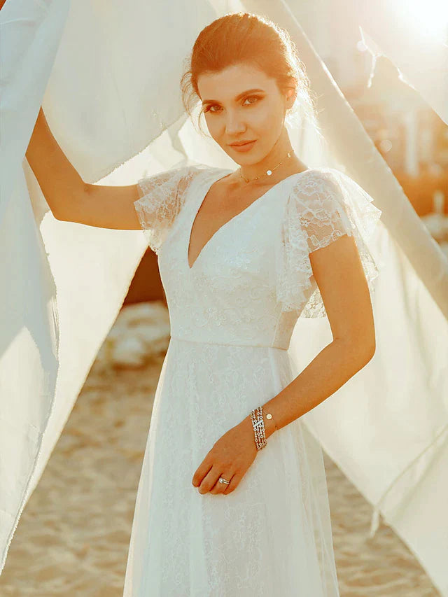 Side profile of a bride in an A-line V-neck short sleeve lace gown.