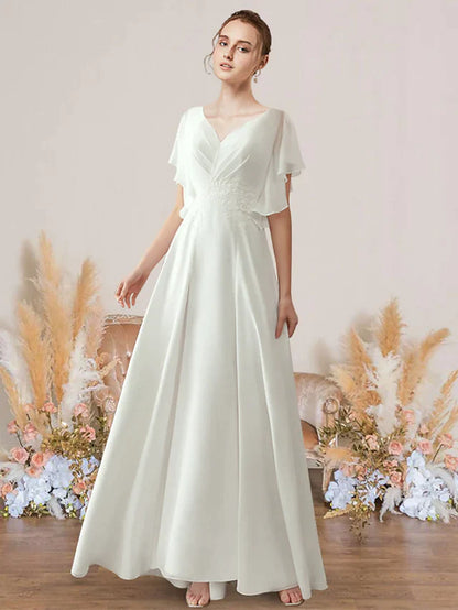 Model wearing an A-Line V-neck short sleeve wedding dress with lace and pleats.