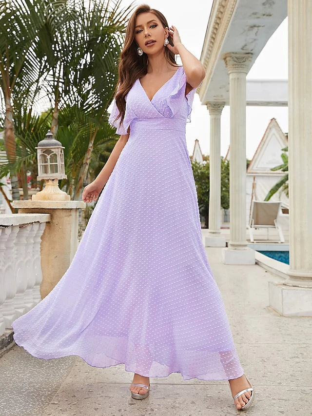 Woman wearing an elegant blue A-line V-neck short sleeve dress with ruffles.