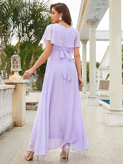 Side view of a woman in a blue chiffon ankle-length party dress.