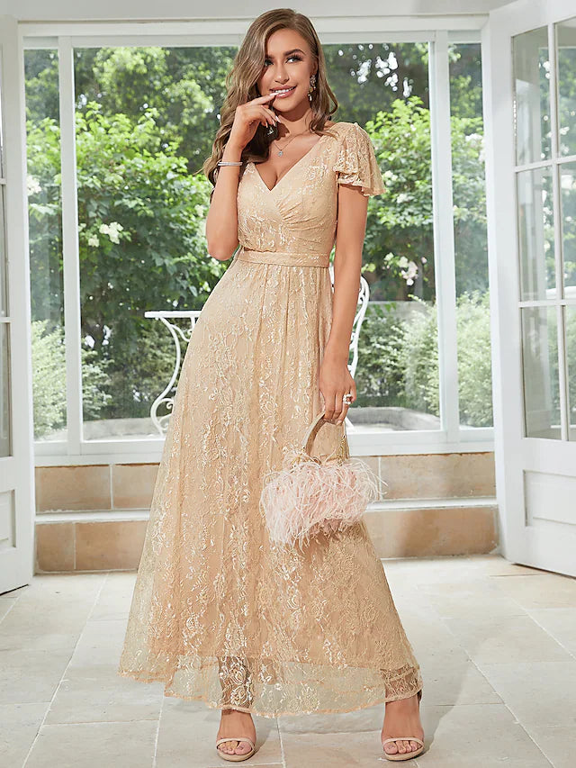 Woman wearing an elegant light-colored A-line chiffon dress with V-neck, short sleeves, and ruffles.