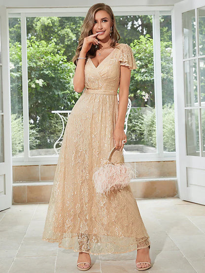 Woman wearing an elegant light-colored A-line chiffon dress with V-neck, short sleeves, and ruffles.