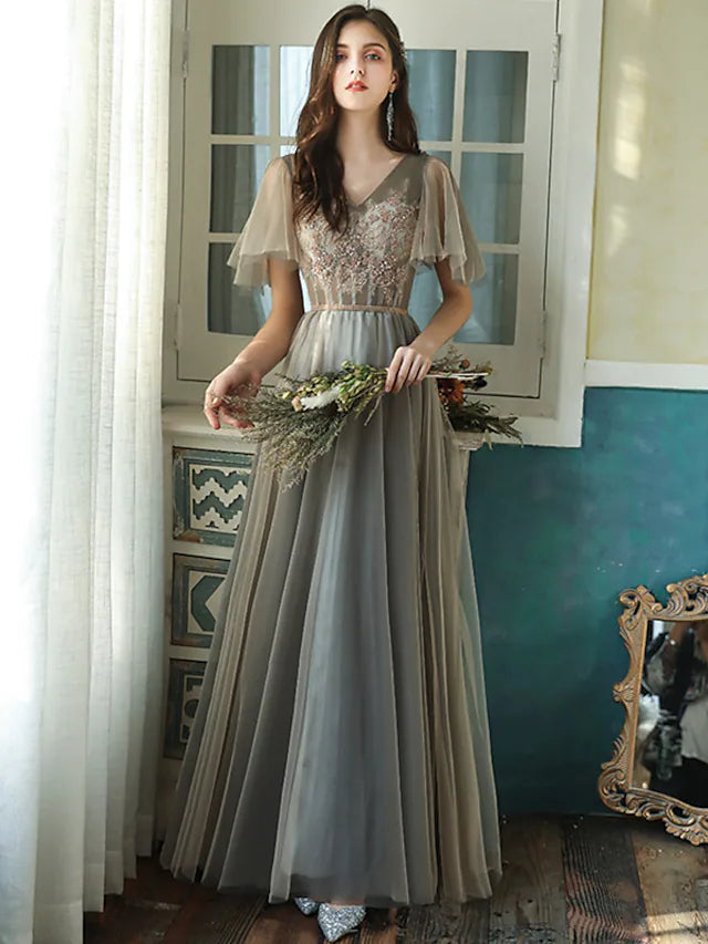 Close-up of the V-neckline and short sleeves with beading on a tulle bridesmaid dress.