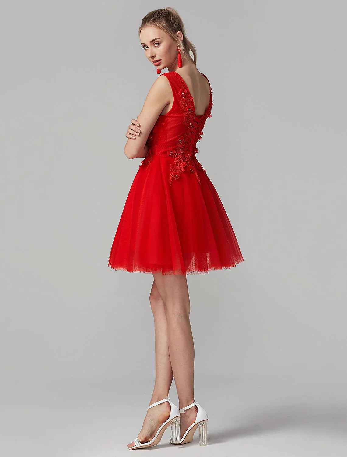 Side view of an A-line short party dress with intricate lace detailing on a model.