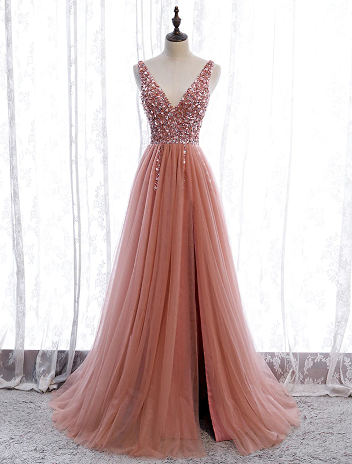 Full-length view of an elegant A-line prom dress with a V-neck, sleeveless design, and pearl embroidery, featuring a court.
