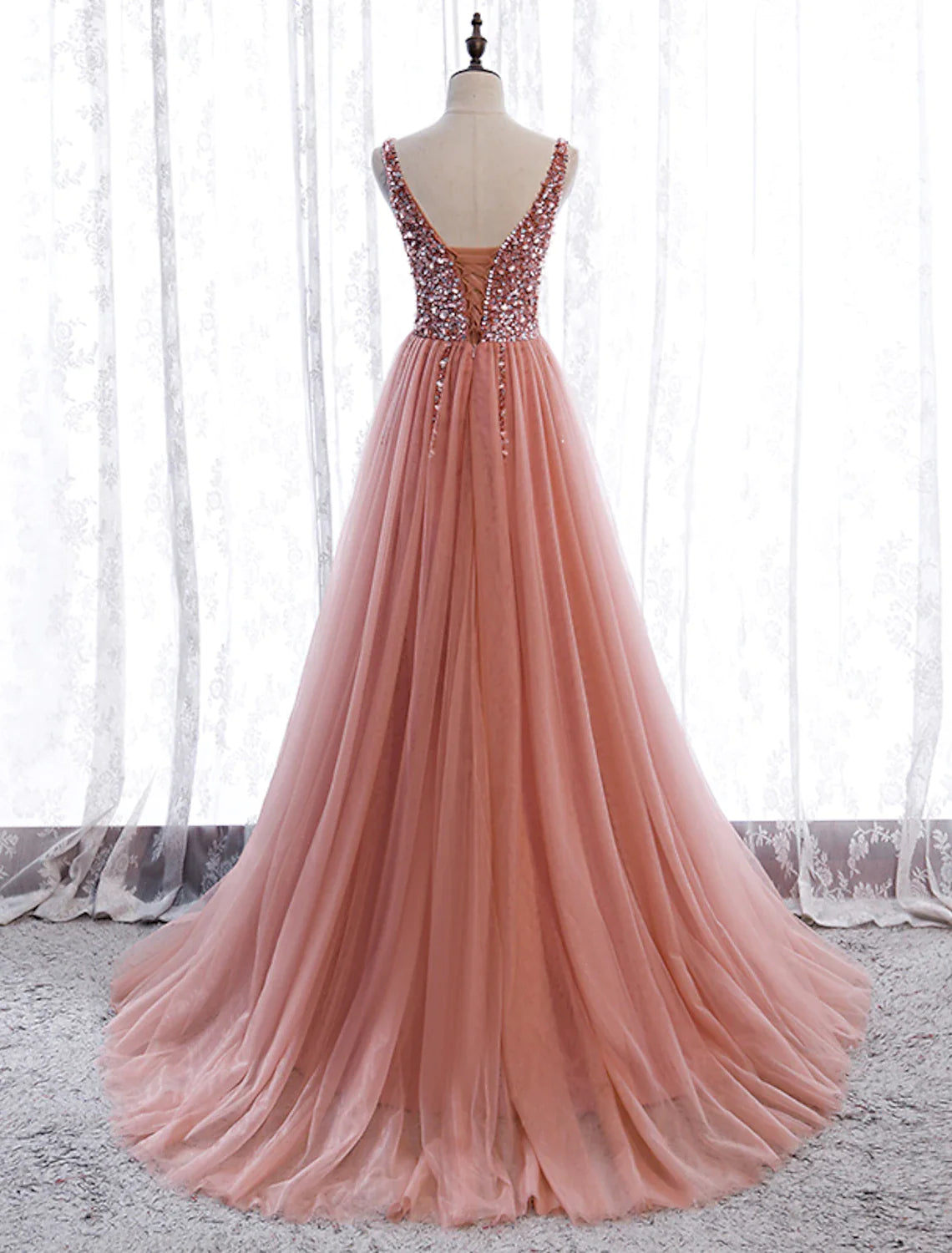 Side view of the A-line prom dress, highlighting the V-neckline, sleeveless cut, and flowing court train.