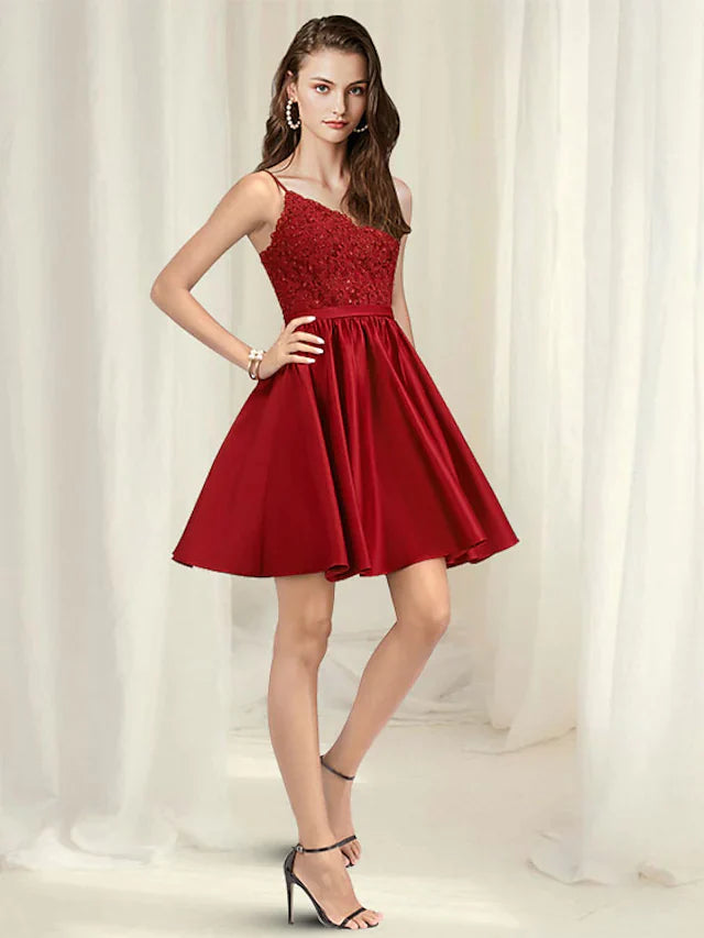 Woman wearing an A-line V-neck spaghetti strap short mini lace satin dress with pleats.