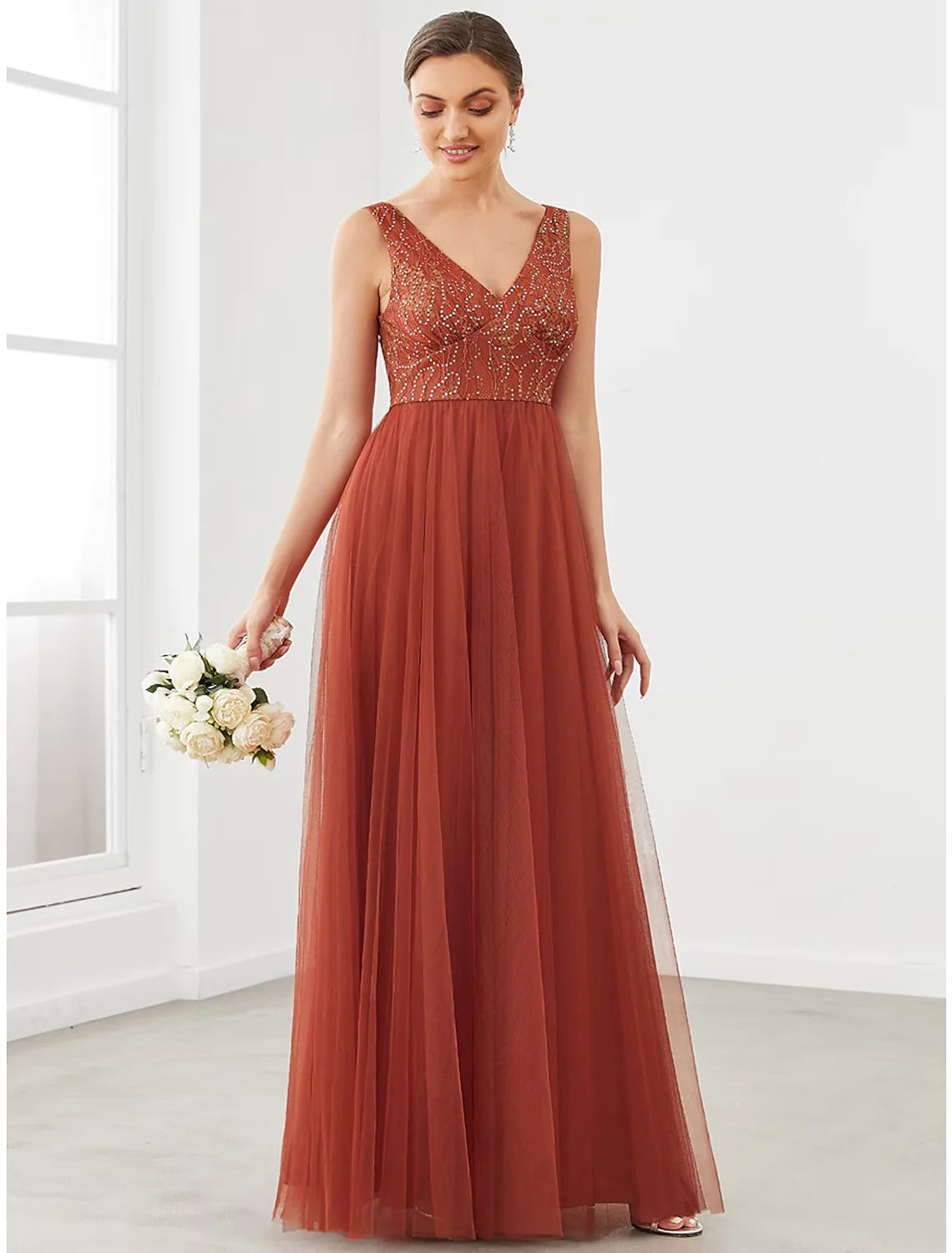 Woman wearing an elegant A-Line V-Neck tulle prom dress with draping details.