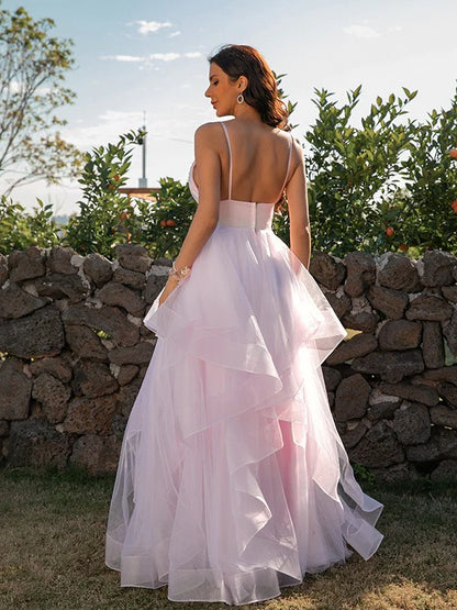 Side view of a woman in a pink A-line V-neck tulle ruffle prom dress.