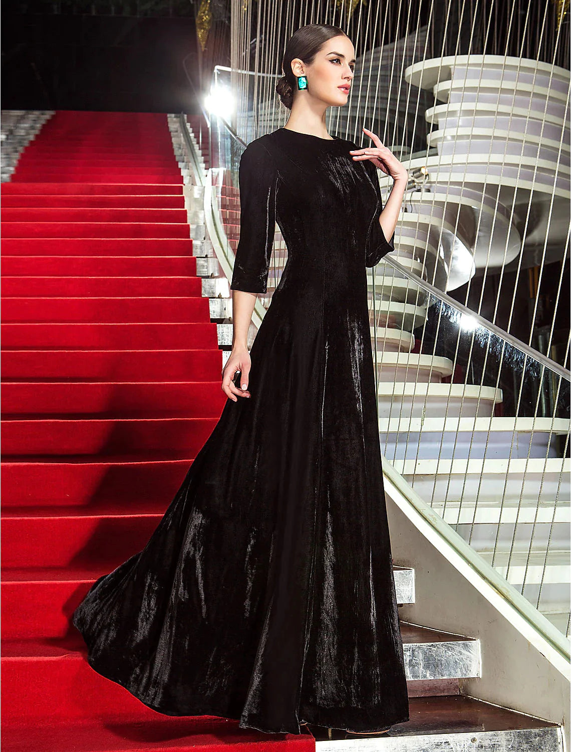 Full view of a woman in a pleated A-line velvet gown, suitable for formal events.