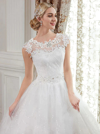 Back view of a floor-length wedding dress showing illusion details and appliques.
