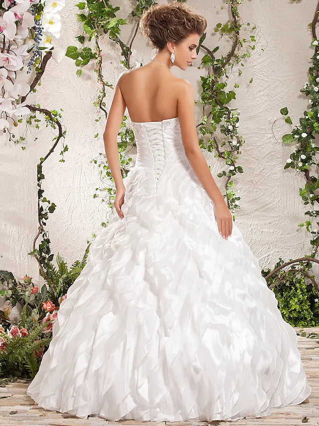 Back view of a bride in a white taffeta ball gown with criss-cross detail.