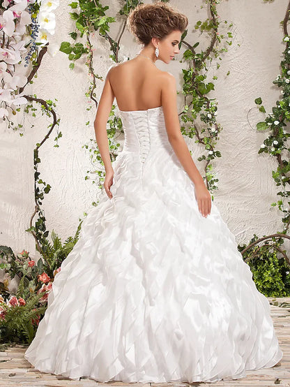 Back view of a bride in a white taffeta ball gown with criss-cross detail.