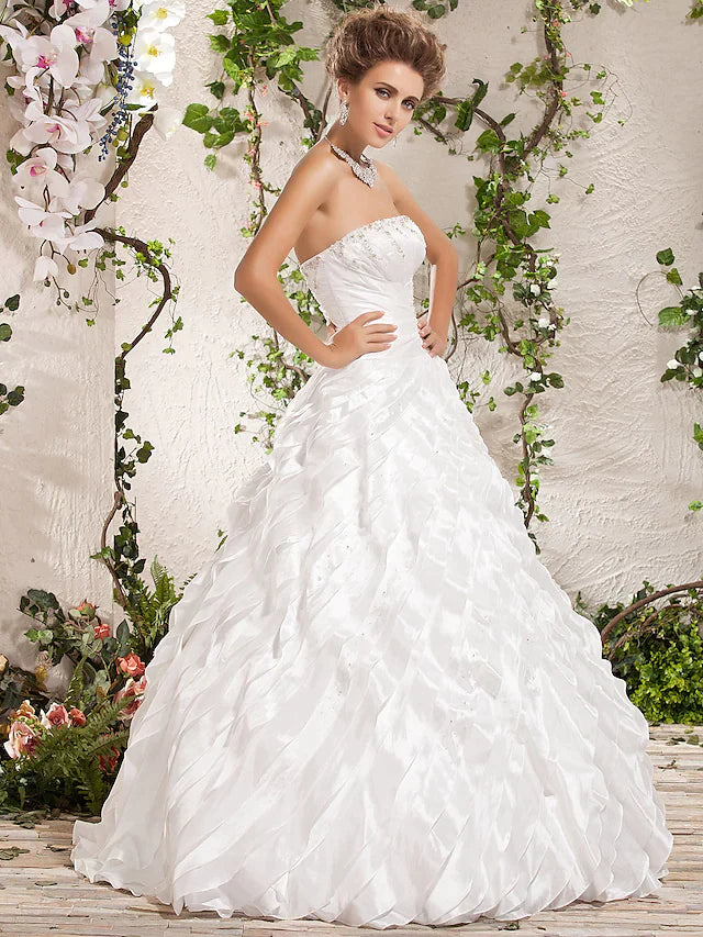 Close-up of the beaded bodice and cascading ruffles on a white wedding gown.