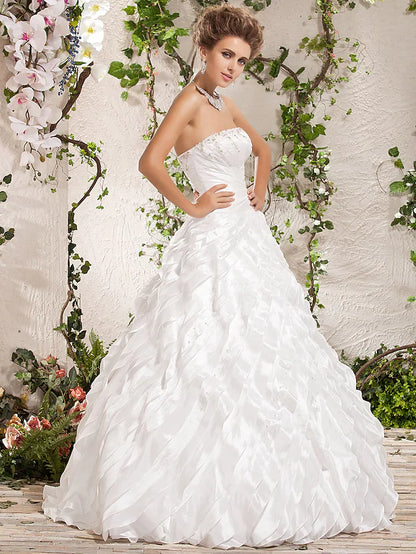 Close-up of the beaded bodice and cascading ruffles on a white wedding gown.