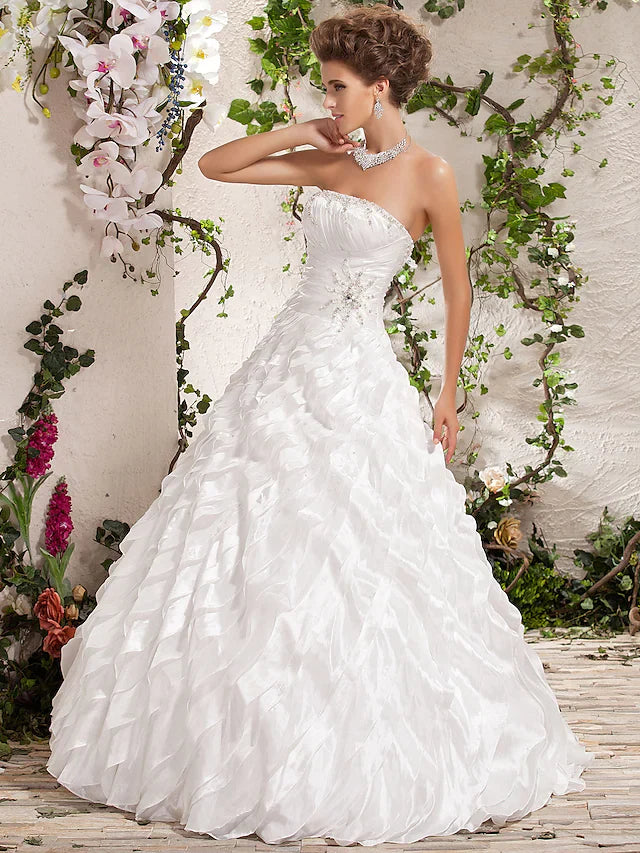 Full length view of a bride posing in a white strapless ball gown.