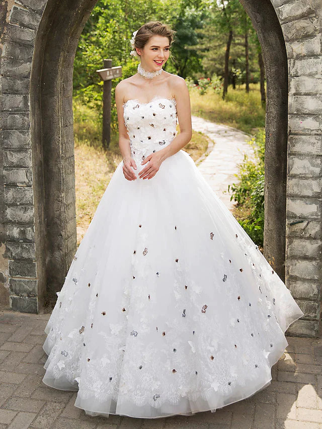 Full view of an elegant ball gown wedding dress with a sweetheart neckline and lace appliques.