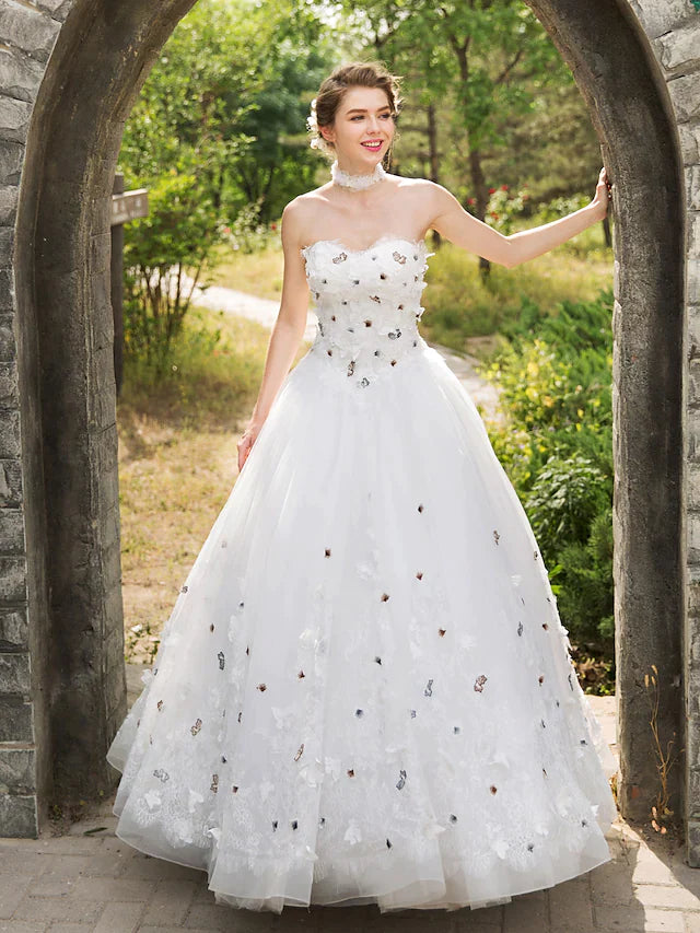 Side profile of the sleeveless lace and tulle wedding dress.