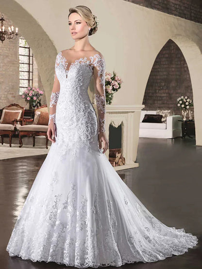 Side view of a bride in a lace wedding dress with a court train.