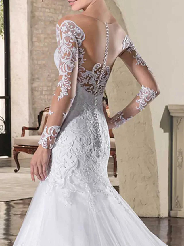 Bride posing in a long sleeve lace wedding gown.