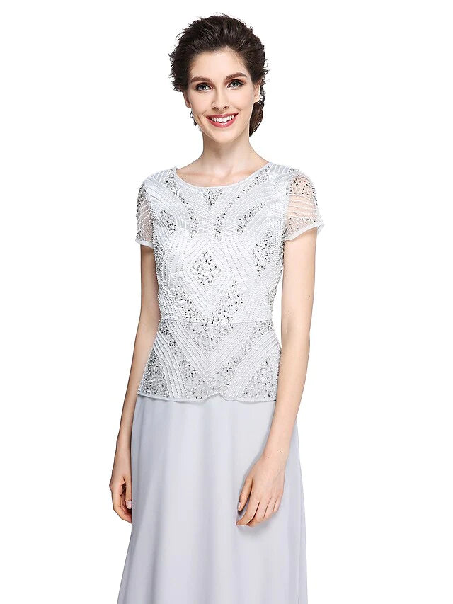 Close-up of the jewel neck and short sleeves on the elegant chiffon dress.