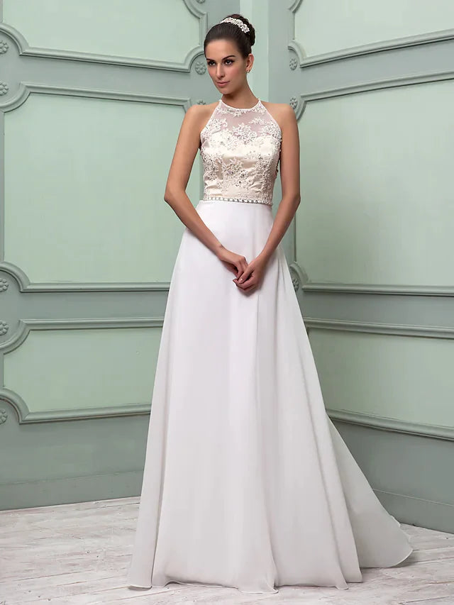 Woman in an elegant white chiffon lace wedding dress with a jewel neck, beaded sash, and split hem.