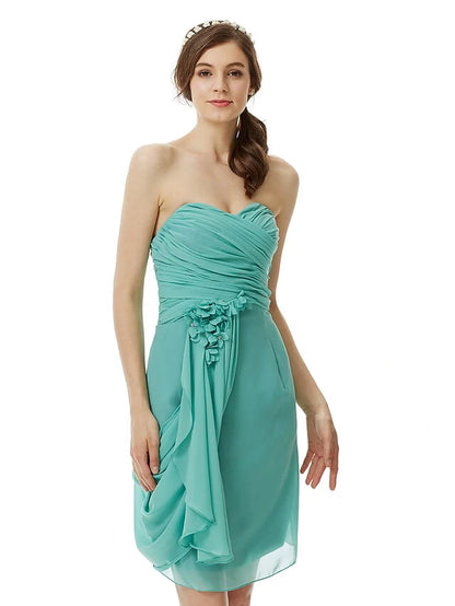 Close-up of the sweetheart neckline and flower detail on the light pink chiffon dress.