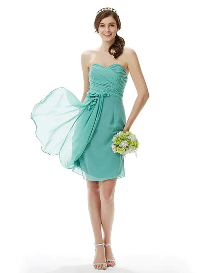Woman posing gracefully in the light pink strapless knee-length chiffon bridesmaid dress.