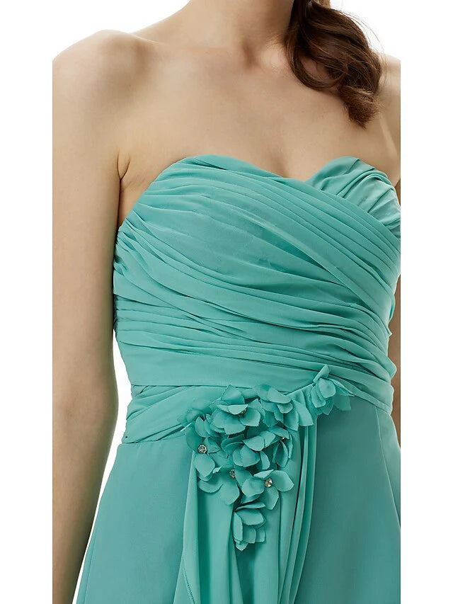 Detailed view of the chiffon fabric and flower embellishment on the light pink dress.