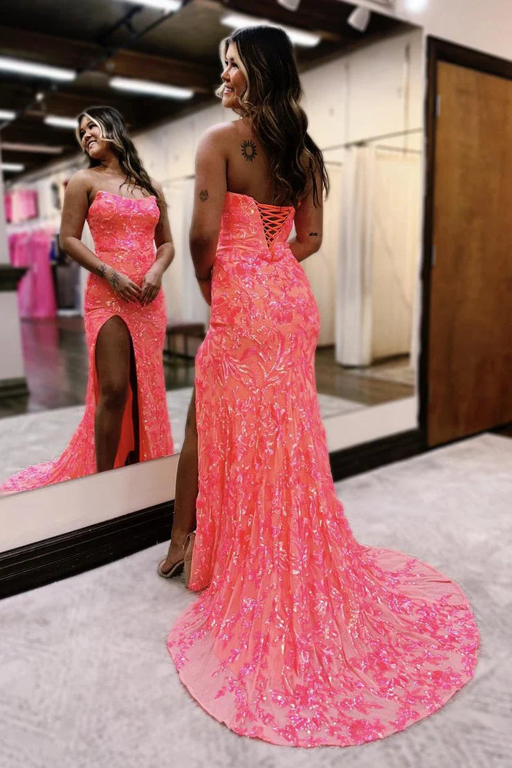 Back view of a model in a shimmering coral sequin strapless mermaid gown with a flowing train.